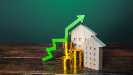 Zielona strzałka w górę nad drewnianymi domami. Rosnący koszt koncepcji mieszkaniowej. Wysoki popyt na nieruchomości. Wzrost oprocentowania kredytów hipotecznych. Sprzedaż mieszkań. Wzrost cen. Koszty utrzymania. Podniesienie podatków od nieruchomości