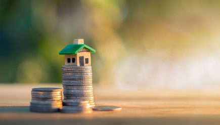 Dom umieszczony na monetach. planowanie oszczędności w monetach na zakup koncepcji domu, koncepcja drabiny nieruchomości, kredytu hipotecznego i inwestycji w nieruchomości. do oszczędzania lub inwestowania w dom.